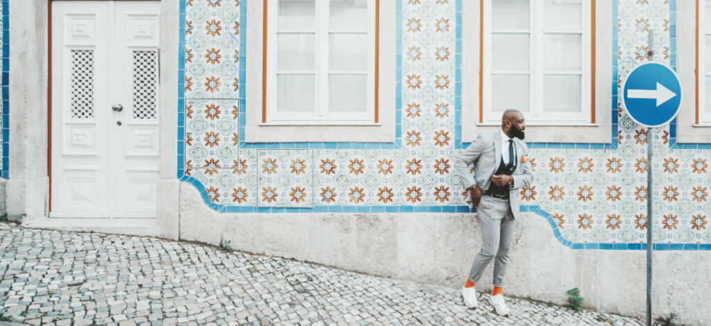 Man on a Lisbon street with azulejo tiles, capturing the vibrant lifestyle that awaits when you move to Lisbon